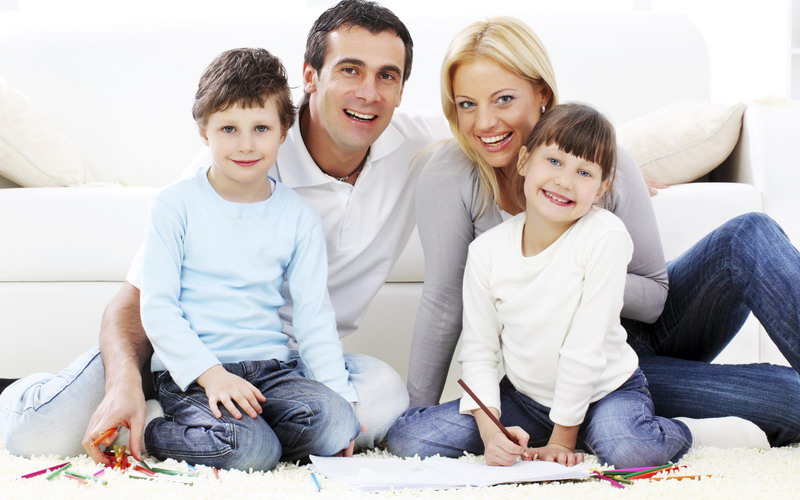 Portrait of a parent with children drawing in colorful pencils.